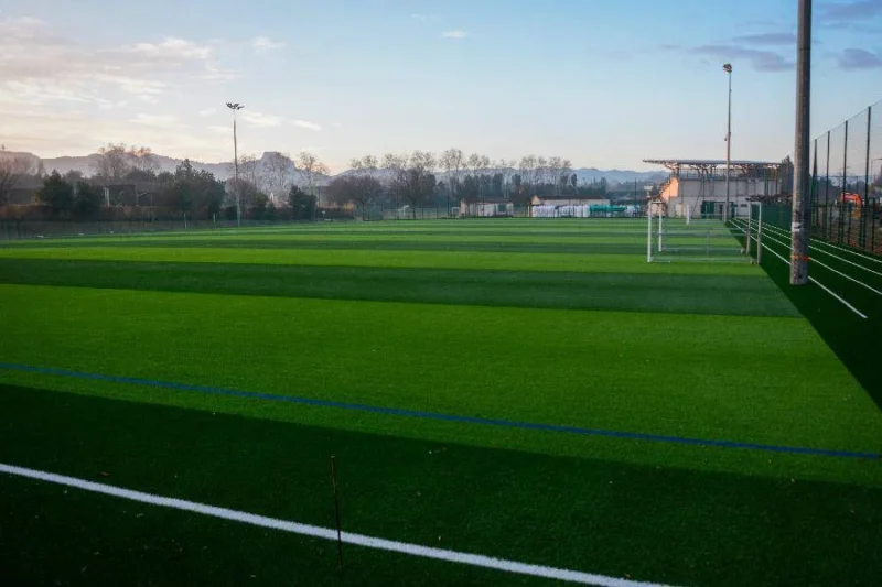 Stade Claude Dupis à Sainte-Hélène — terrain de football synthétique vert au coucher du soleil